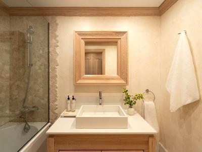 Modernes Badezimmer mit Holzmöbeln, weißen Waschbecken und Dusche neben der Badewanne.