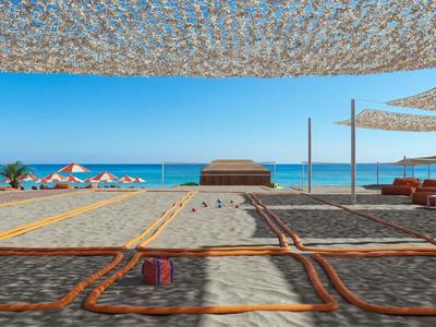 Sonnenschirme und Sitzbereiche am Strand mit Meer und klarem Himmel im Hintergrund.