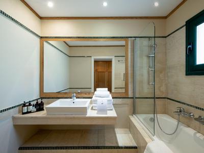 Modernes Badezimmer mit Waschbecken, Badewanne und kleinen Pflegeartikeln im Hotelzimmer.