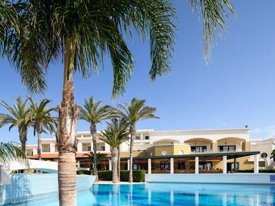 Hotel con piscina e palme sotto cielo azzurro di giorno