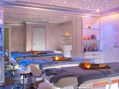 Modern gestalteter Wellnessraum mit zwei Liegen, sanfter Beleuchtung und entspannender Atmosphäre.