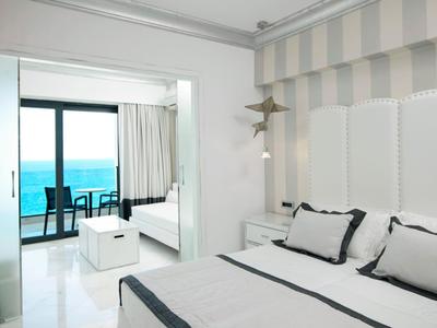 Modernes Schlafzimmer mit Meerblick und Balkon in einem Hotelzimmer.