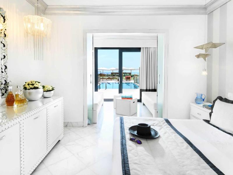 Camera da letto luminosa con grande finestra con vista sull'acqua, arredamento moderno e minimalista.