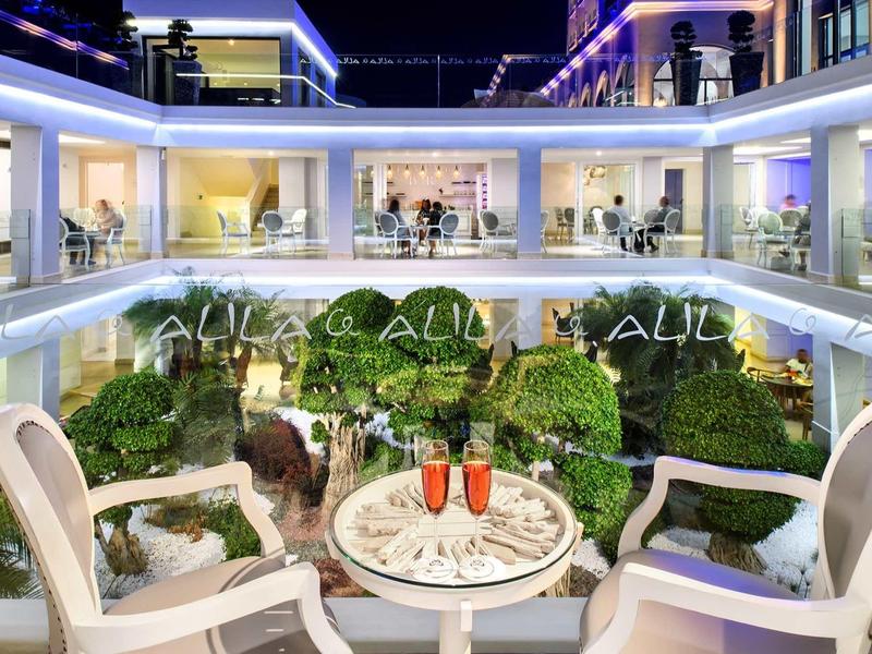 Area salotto elegante con flûte di champagne in un cortile d'hotel ben illuminato