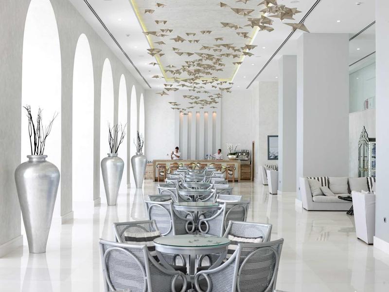 Ristorante d'hotel luminoso ed elegante con grandi archi, mobili moderni e design decorativo del soffitto.