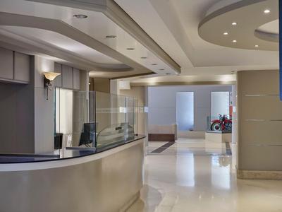 Area reception dell'hotel moderna con banco elegante e design luminoso e aperto.