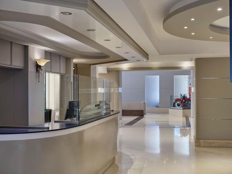 Reception d'hotel moderna con interni luminosi e bancone elegante.