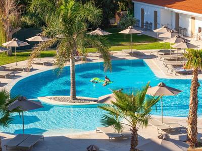 Area piscina con ombrelloni e palme in un resort