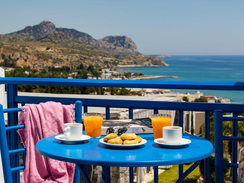 Modrý stůl na balkoně se snídaní s výhledem na moře a hory