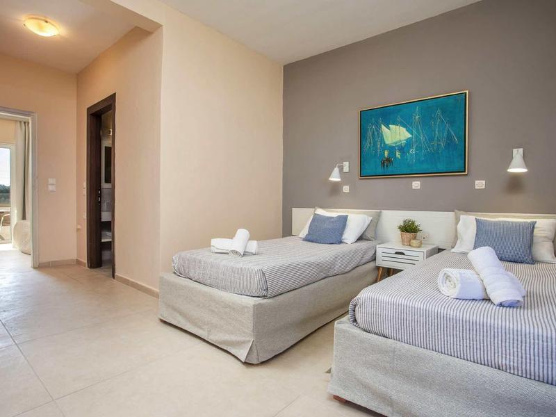 Camera d'hotel moderna con due letti singoli e accesso alla terrazza.