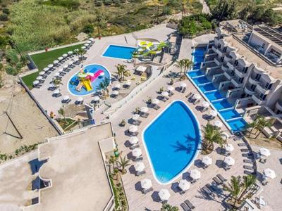 Veduta aerea di un hotel con due piscine, scivoli d'acqua e ombrelloni.