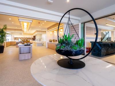 Moderna hall dell'hotel con seggiola sospesa e piante come decorazione