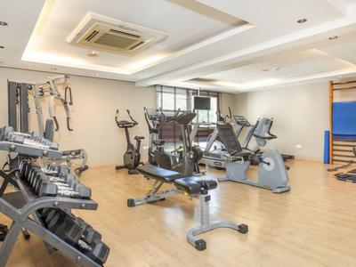 Salle de sport lumineuse avec divers équipements d'exercice et sol en bois