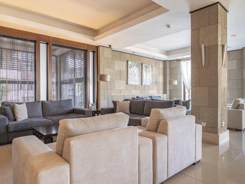 Nowoczesny salon hotelowy z wygodnymi sofami i ciepłym oświetleniem.