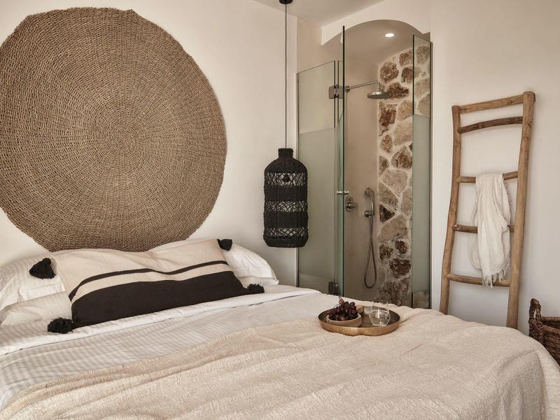 Camera accogliente con tappeto rotondo, doccia moderna e scala decorativa sulla parete.