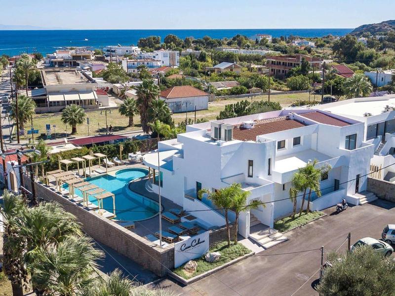 Case vacanze bianche moderne con piscina vicino al mare in un ambiente verde e soleggiato.