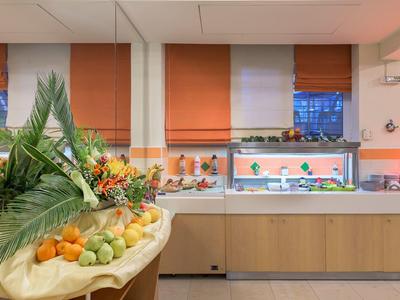 Fruit- en groentestation in een lichte, moderne ontbijtruimte met oranje jaloezieën.