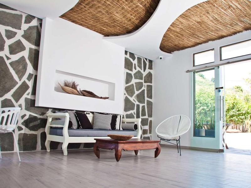 Modern living area with carpet floor, sofa, designer table, and large windows beside the door.