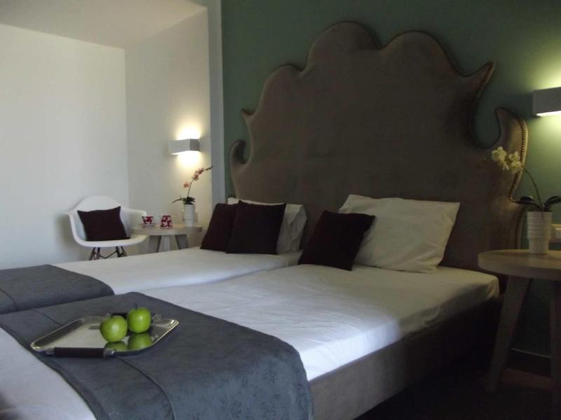 Cozy hotel room with large bed, dark gray headboard, and decorative pillows.
