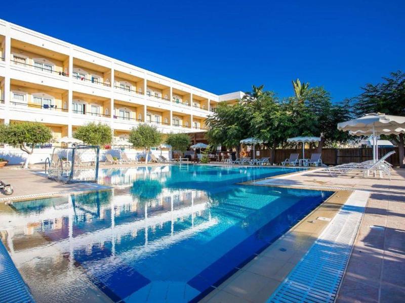 Piscina moderna dell'hotel con sdraio e ombrelloni sotto un cielo azzurro.