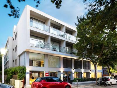 Edificio moderno di un hotel su più piani con balconi e parcheggi davanti.