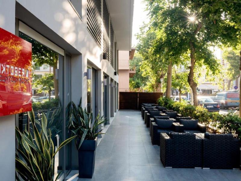 Modern outdoor seating area with plants next to a hotel.