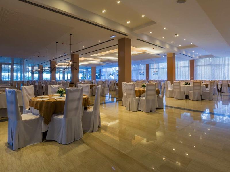 Duża jadalnia z nakrytymi stołami i widokiem na okna od podłogi do sufitu