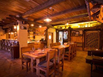 Restaurante acogedor con muebles de madera y luz cálida, ideal para una noche relajada.