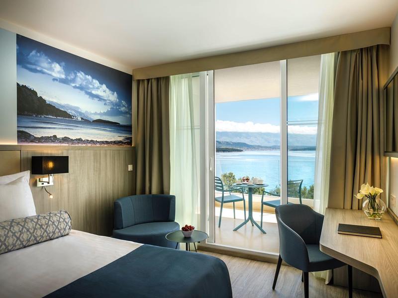 Moderní hotelový pokoj s výhledem na moře, balkonem a komfortním zařízením.