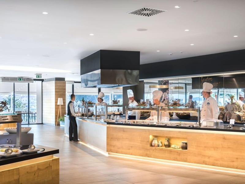 Nowoczesny bufet hotelowy z różnorodnymi potrawami i uprzejmą obsługą.