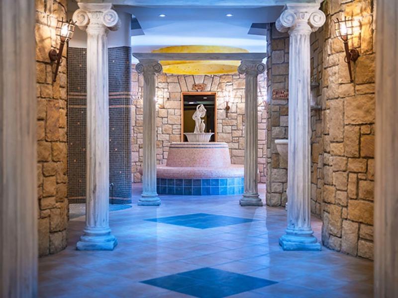 Luksusowy korytarz spa z kamiennymi kolumnami i niebieskim oświetleniem ambientowym