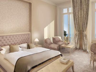 Camera luminosa con letto elegante, poltrone e grandi finestre con vista