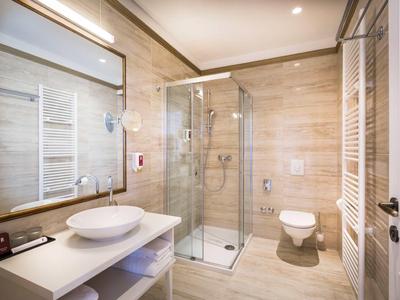 Bagno moderno con doccia in vetro, lavabo sul piano e toilette.