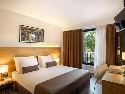 Modern hotelkamer met tweepersoonsbed, bureau, stoel en balkon