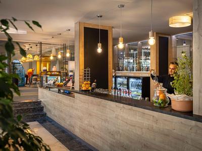 Réception d'hôtel moderne avec comptoir et éclairage élégant dans une ambiance chaleureuse.