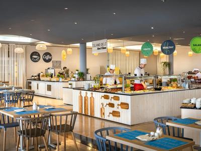 Buffet de petit-déjeuner lumineux avec meubles en bois et décoration moderne dans un restaurant d'hôtel.