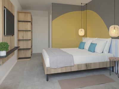 Moderní hotelový pokoj s manželskou postelí, žlutým akcentem na stěně a minimalistickým nábytkem.