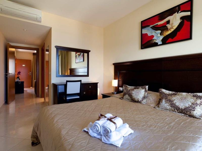 Camera da letto moderna con letto matrimoniale, lampada da comodino e quadro decorativo.