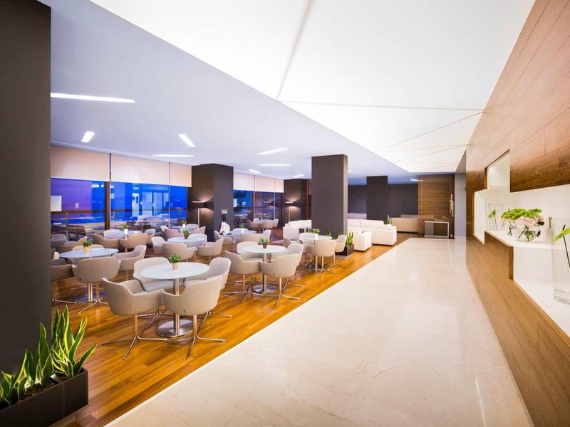 Modern hotel dining area with wooden flooring and stylish chairs in the evening.