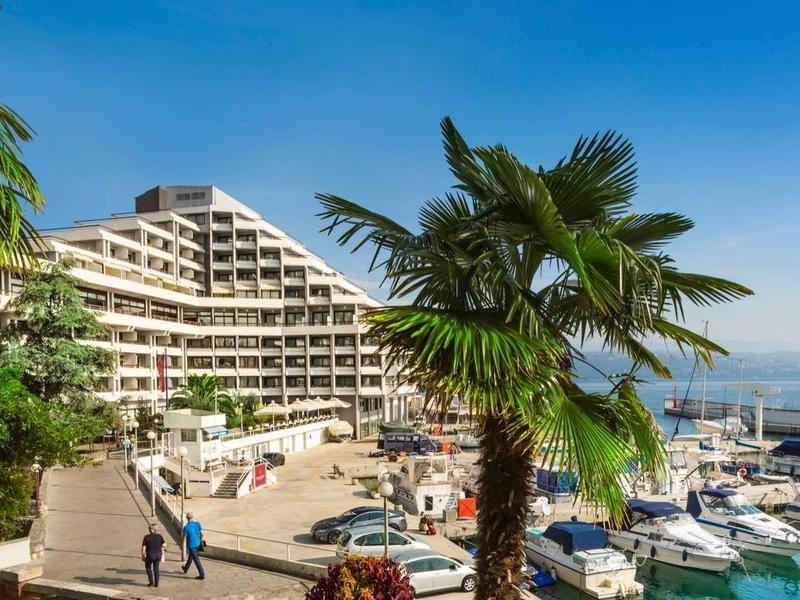 Harbor with yachts and hotel building under sunny weather and blue sky