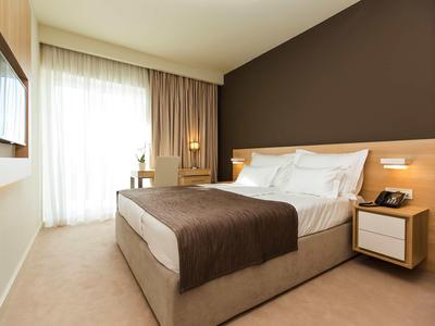 Chambre d'hôtel moderne avec grand lit et fenêtre avec rideaux