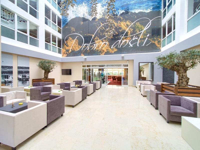 Heller, moderner Hotel-Lobbybereich mit bequemen Sitzmöbeln und großer Wandkunst.