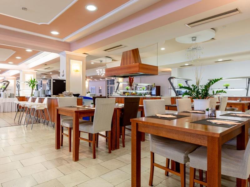 Helles Hotelrestaurant mit Holztischen, bequemen Stühlen und moderner Innenausstattung.