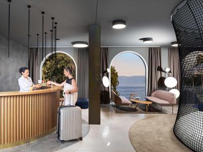 Moderne hotel lobby met receptie, zithoek en uitzicht op zee door een raam