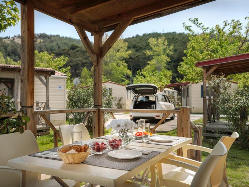Cozy outdoor dining area with set table overlooking green hills.