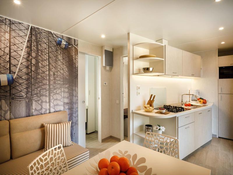 Cucina moderna con arredi bianchi e zona pranzo aperta in un appartamento luminoso.