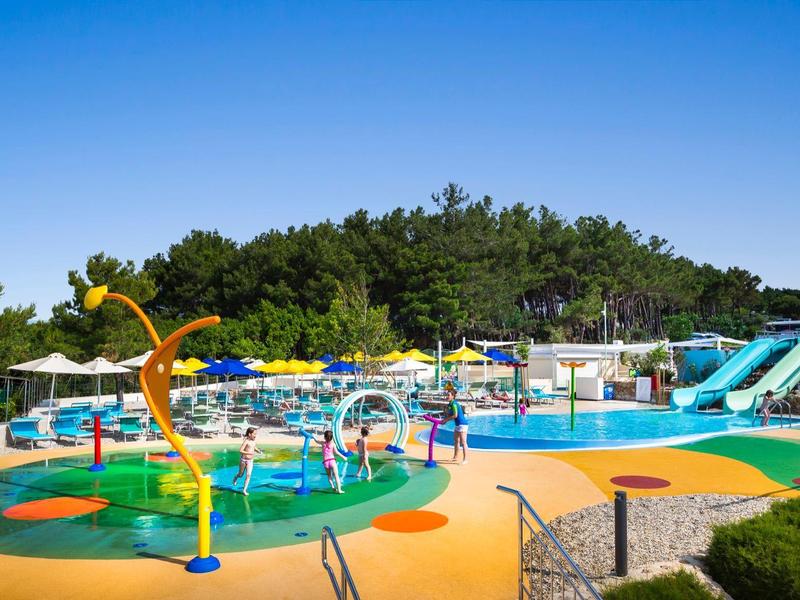 Colorful water playground with slides and water sprays under clear blue sky