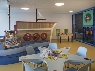 Strefa zabaw dla dzieci z łodzią i stołem w jasnym, kolorowym pomieszczeniu.