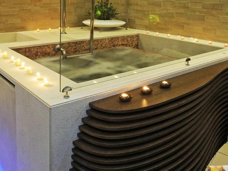 Modern wellness area with jacuzzi, indirect lighting, and comfortable seating.