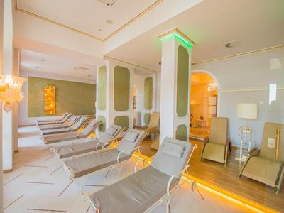 Relaxation room with multiple gray lounge chairs and warm, indirect lighting.